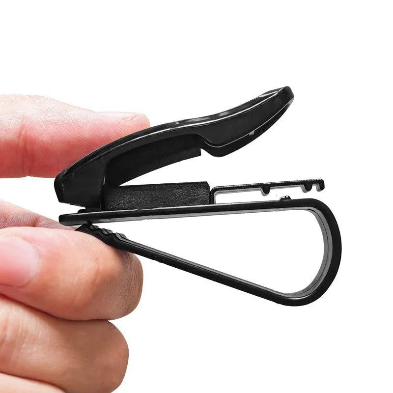 Black plastic car sun visor clip for holding glasses and cards.