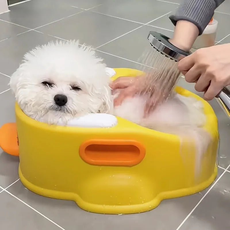 Blue PVC duck-shaped bathtub for washing a small dog, shown on a bathroom floor.