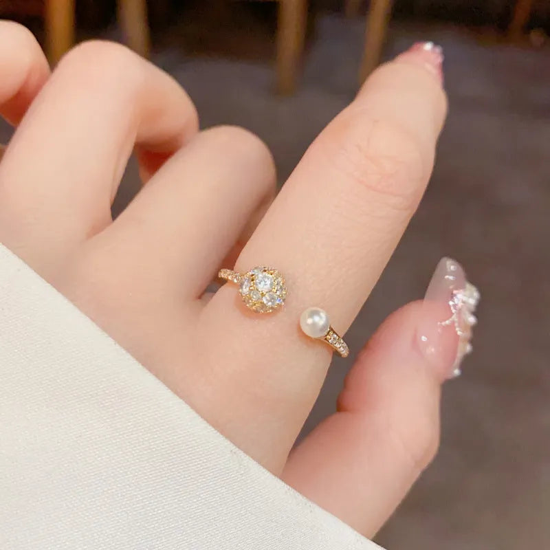 Open-end women's ring with round zircon detailing and pearl elements in gold or silver plated finish