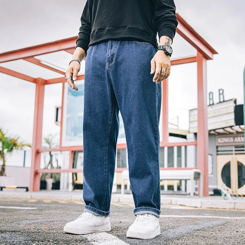 Men's loose straight blue jeans on hanger showing mid-waist design and straight leg cut