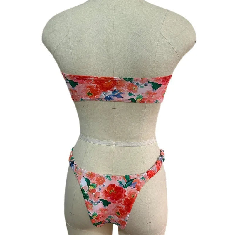 Women's floral print tube top bikini set with lace trim on a blue background.