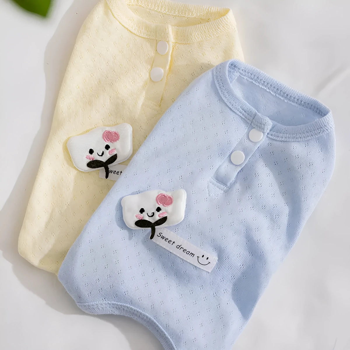 Breathable mesh pet shirt for small dogs and cats in blue or yellow with cat patch and button closure