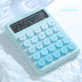A gradient colour desktop calculator in violet, pink, blue, or green on a desk.
