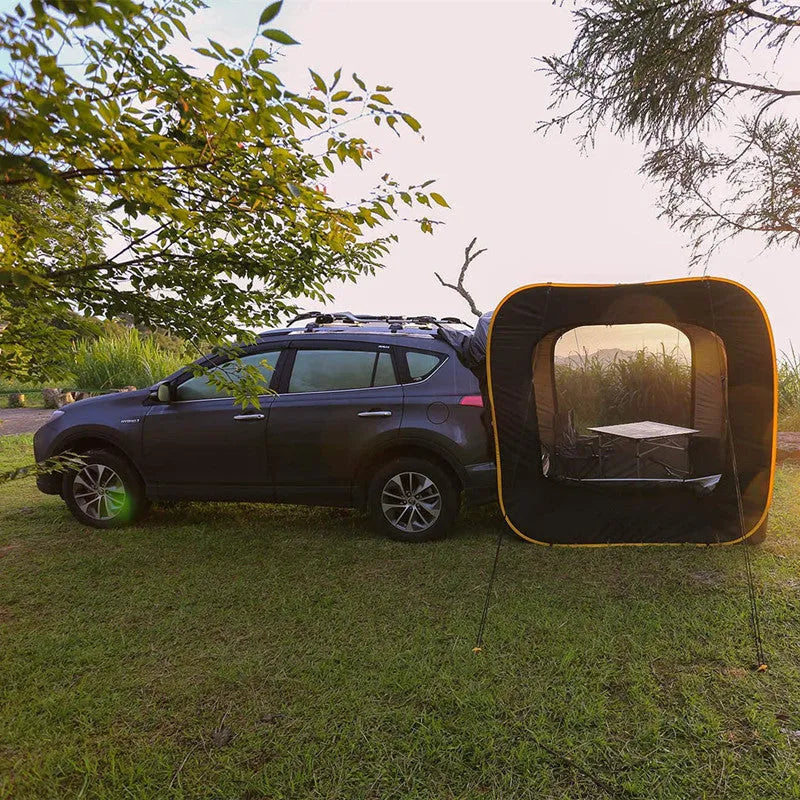 Black pop-up outdoor camping car tail tent with quick set-up, shown unfolded next to a vehicle.