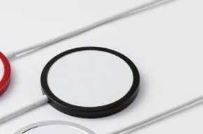 Silver metal Magsafe-compatible magnetic wireless charger for iPhone 12 and 13 series.