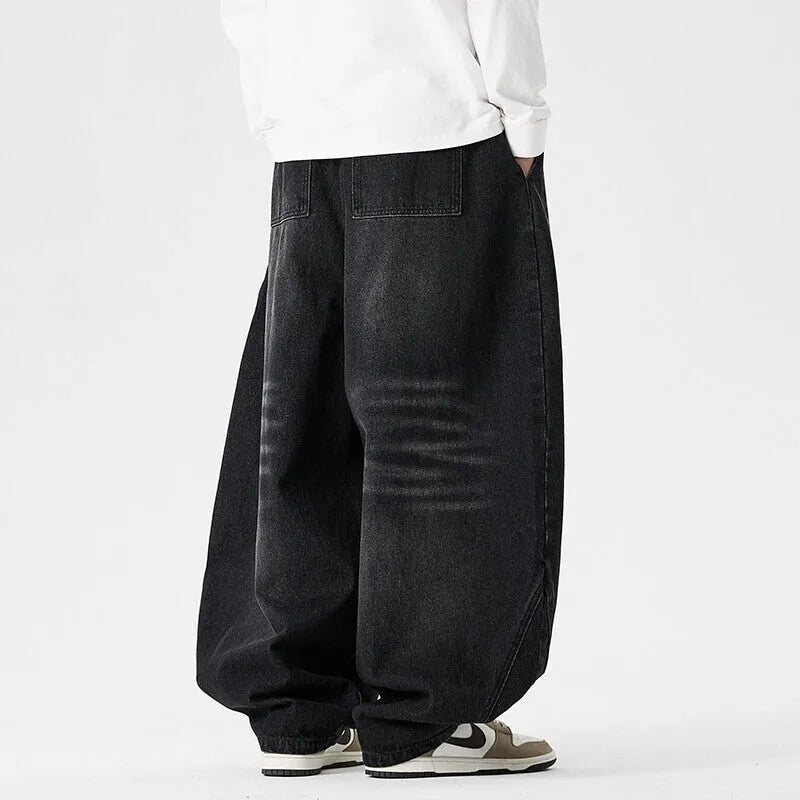Men's loose fit light blue denim jeans with a straight leg and low waist, laid flat.