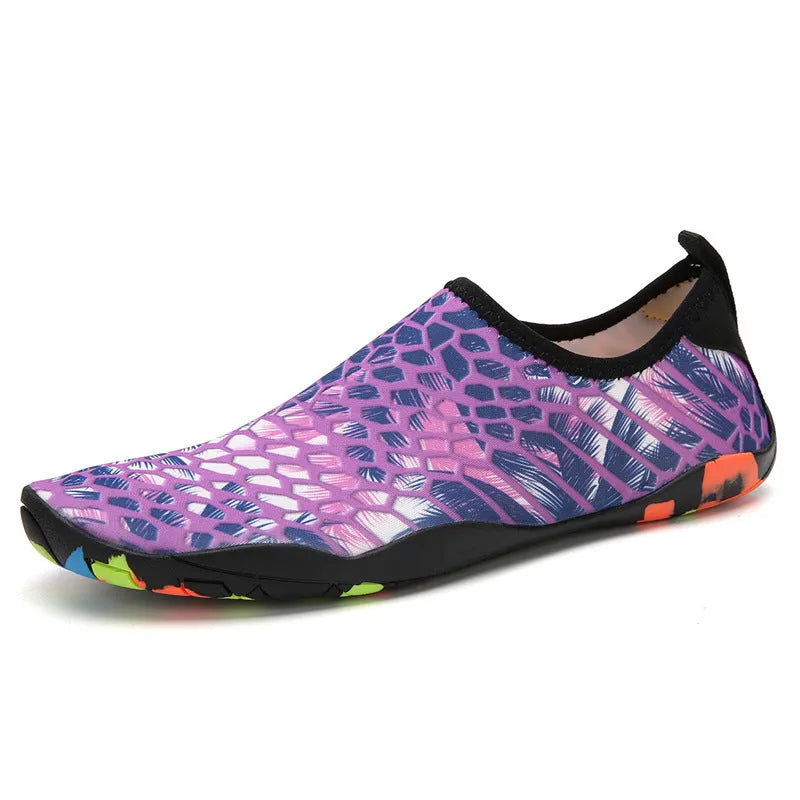 Pair of blue Lycra beach wading shoes with EVA midsole on a sandy beach background.