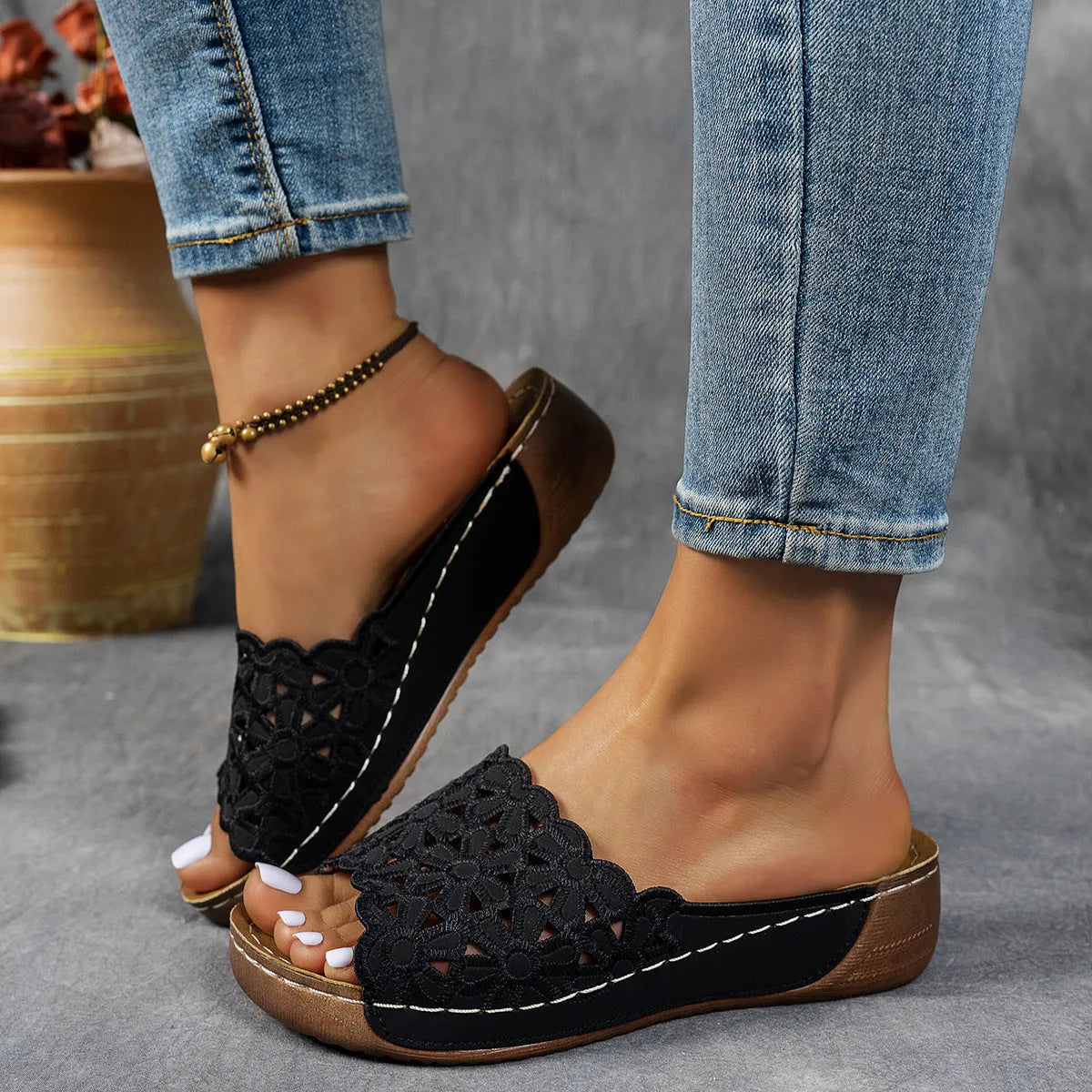 Women's black wedge beach slippers with floral cutouts and an open fish mouth toe design.