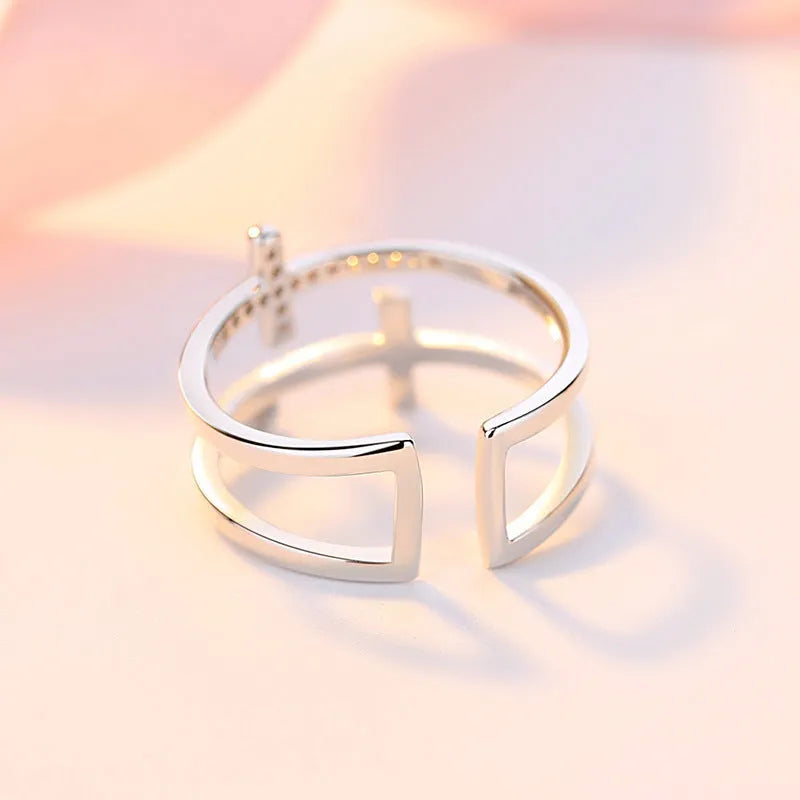 Women's adjustable double cross copper ring with zircon stones in sterling silver inlay, shown in a gold electroplated finish.