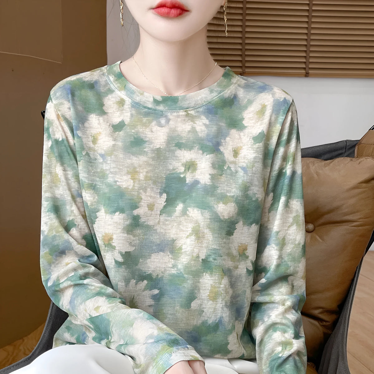 Floral print round neck pullover in knitted Tencel cotton fabric on a hanger.