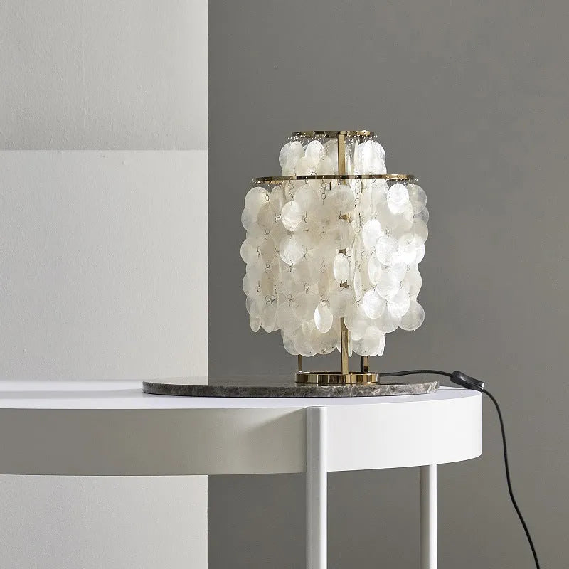 Modern single-head Shell bedside table lamp in chrome finish on a wooden table.