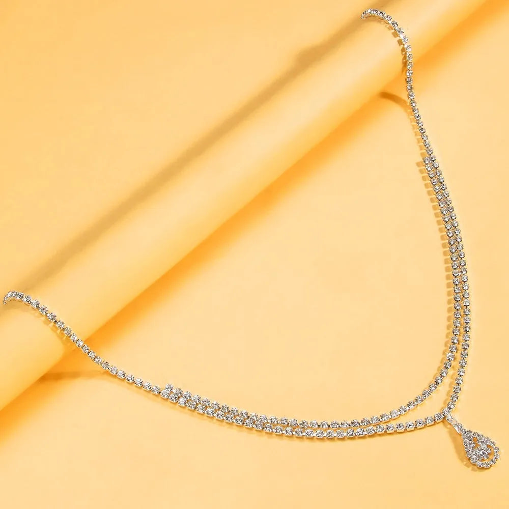 Gold waist chain with water drop pendant and rhinestone tassel measuring 115cm