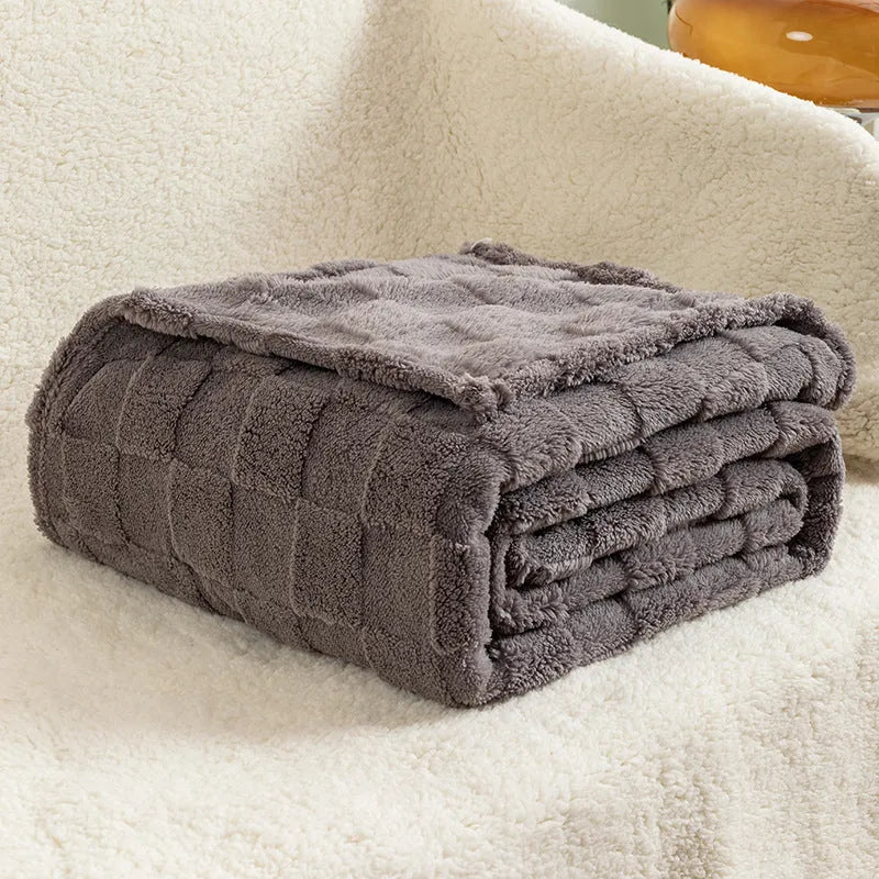 Geometric pattern polyester blanket in milky white colour on grey sofa