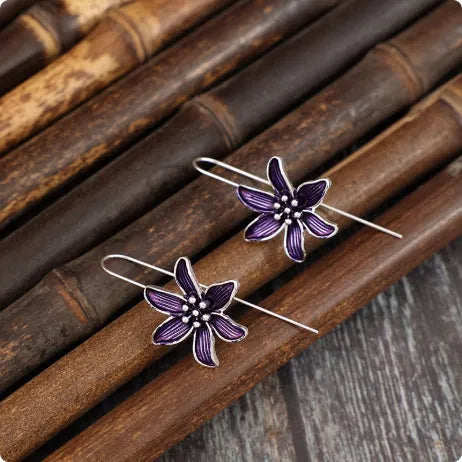 Purple floral alloy drop earrings with retro design on white background