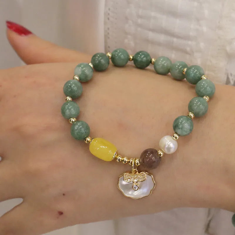 Green jade bracelet with shell pattern beads on an adjustable black cord.