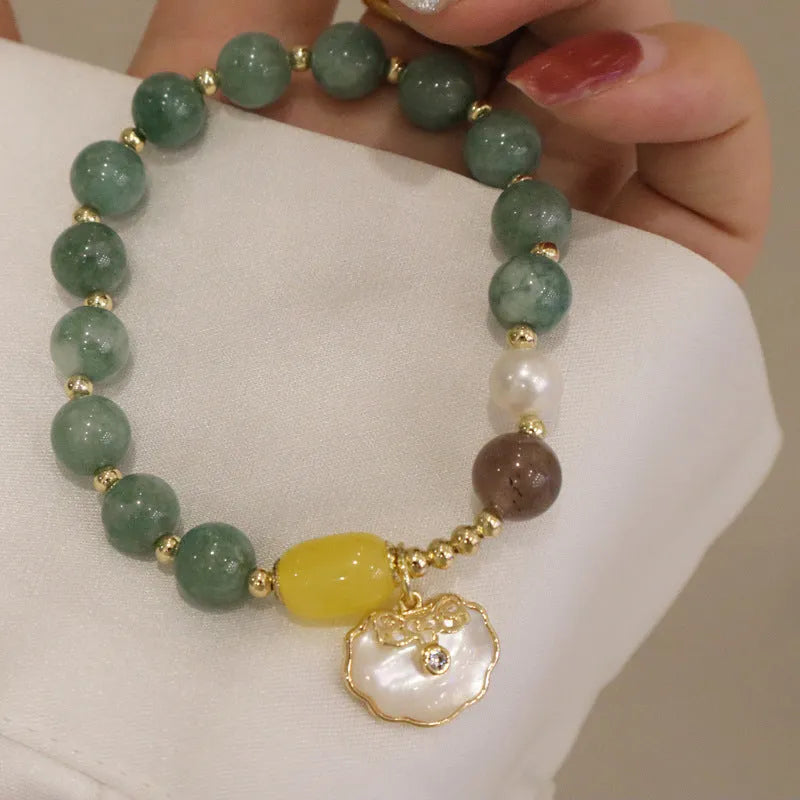 Green jade bracelet with shell pattern beads on an adjustable black cord.
