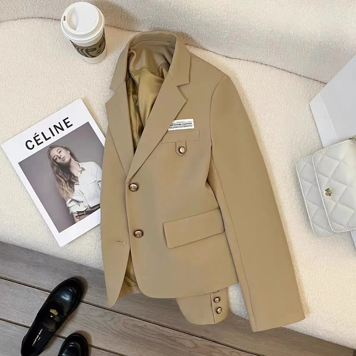 Women's black loose-fit suit coat with long sleeves and pockets on a hanger.