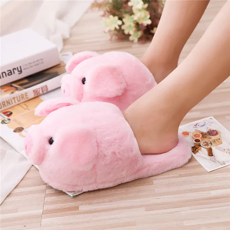 Pink plush pig-themed floor slippers on a white background.