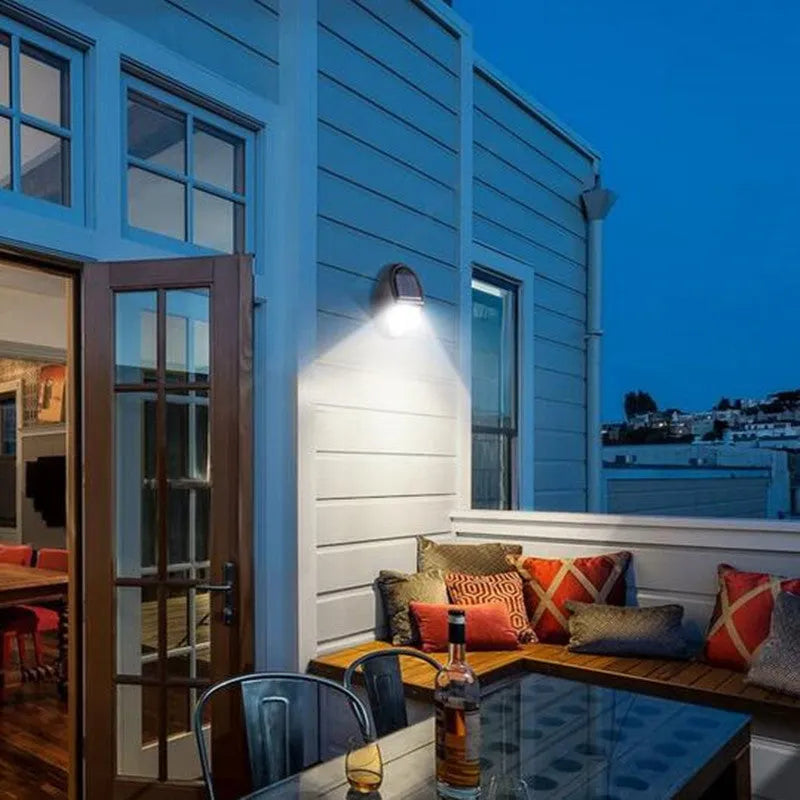 Black solar-powered wall light with solar panel and LED illumination