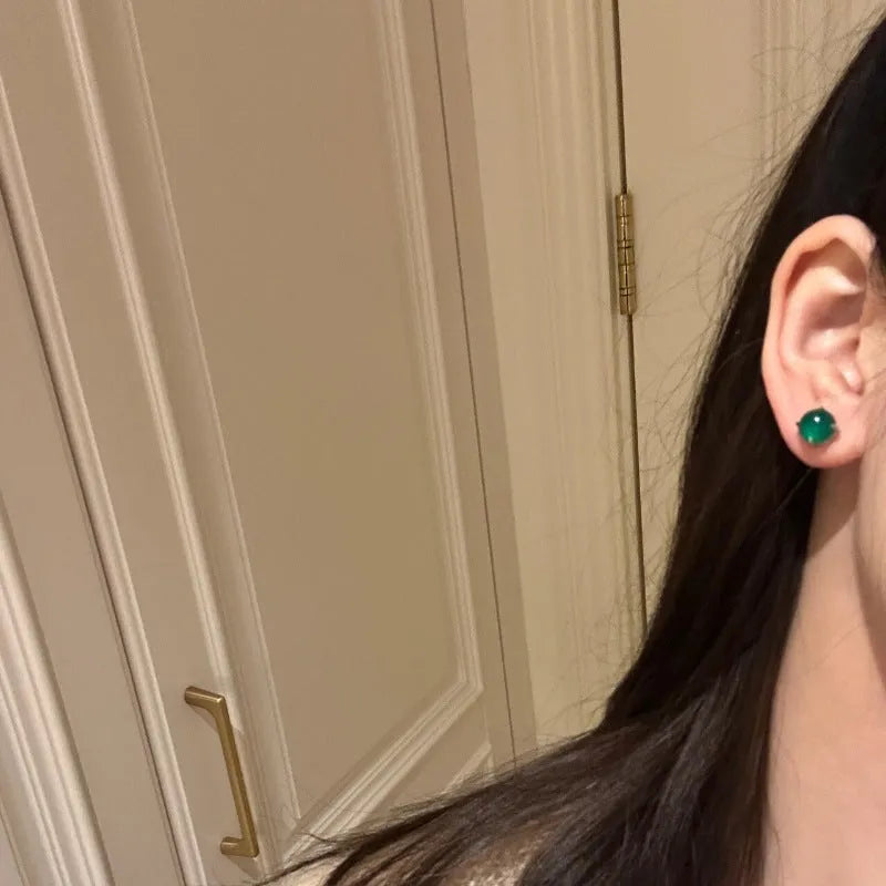 Round chalcedony stud earrings with four claw copper settings in green, white, or pink.