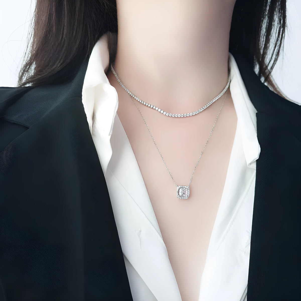 Close-up of a women's sterling silver necklace with round diamond-cut elements on a polished chain.