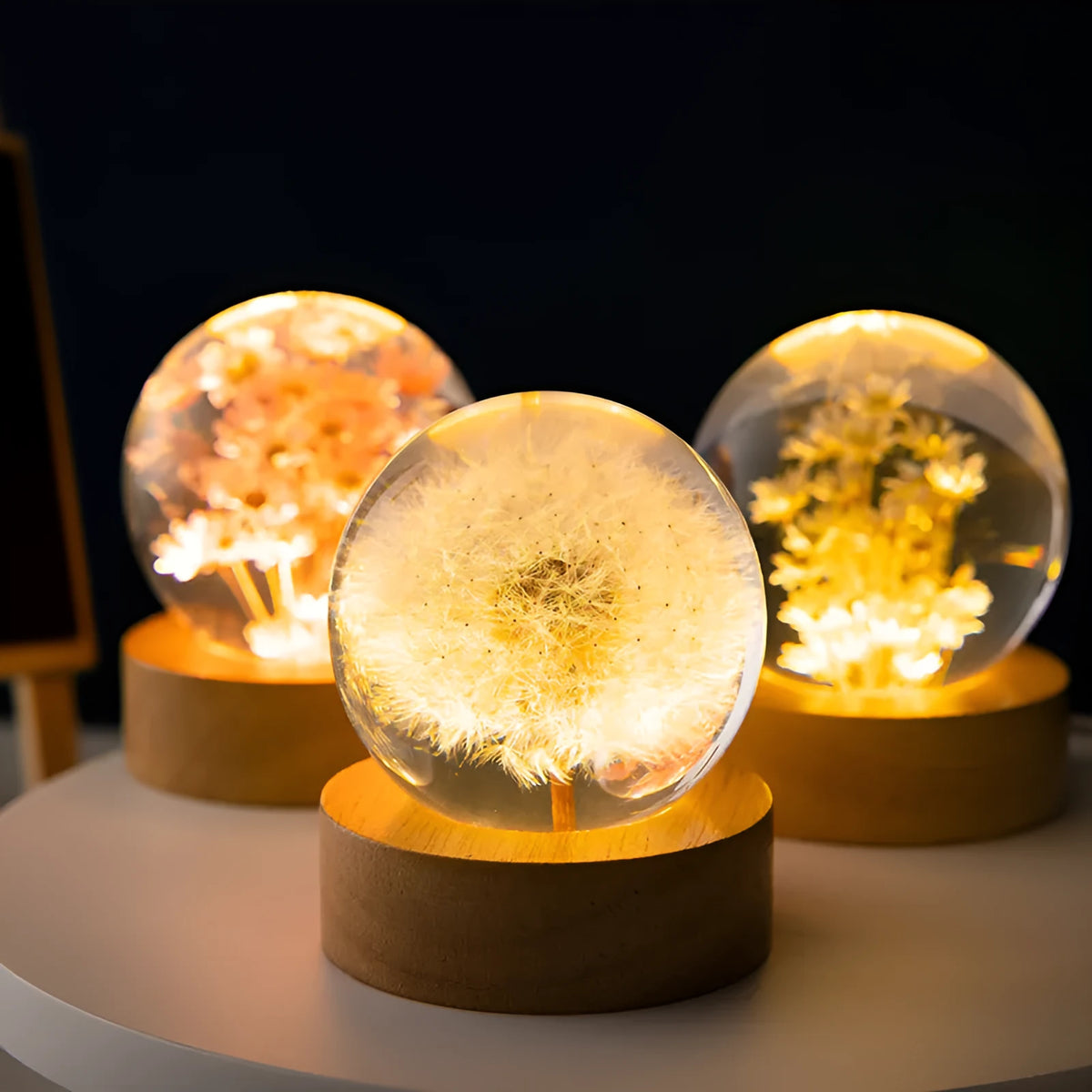 3D dandelion inside a clear resin crystal ball night light on a beech wood stand.