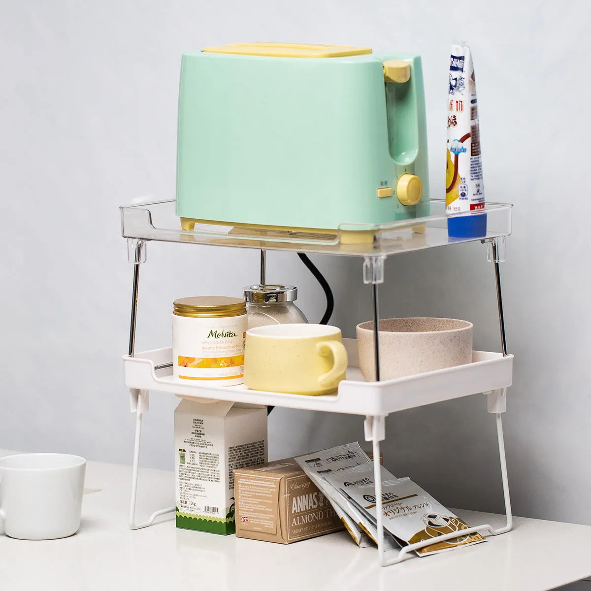 Plastic kitchen supplies rack in transparent and white colour options for desktop or cupboard organisation