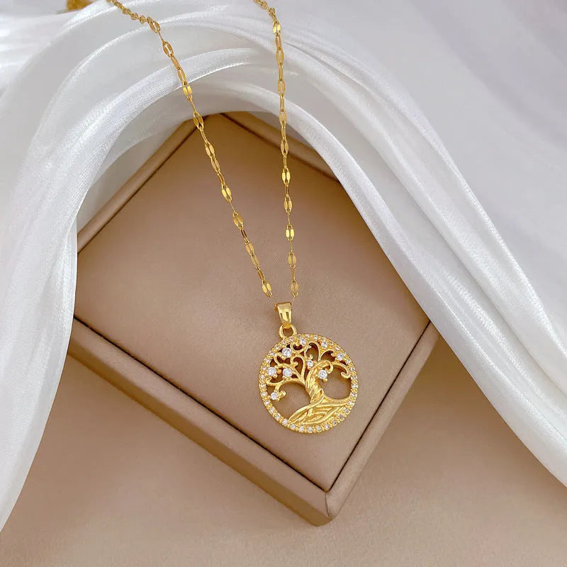 Gold-plated necklace with rhinestone tree pendant featuring mother-of-pearl detail on adjustable lip chain