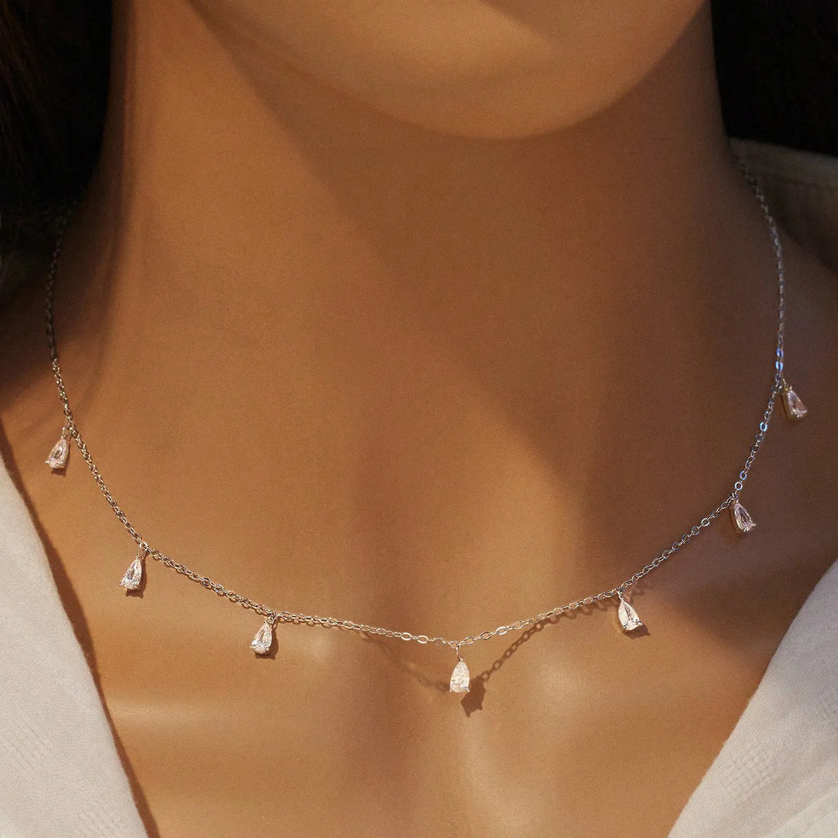 Gentle drop-shaped silver necklace with triangular details on an adjustable O-chain, shown in rose gold finish.