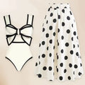 Women's black one-piece swimsuit with white round skirt and bow, worn as a beach dress.
