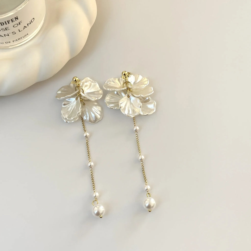 Women's acrylic fashion earrings with white shell and pearl tassel design on a silver-toned ear clip.