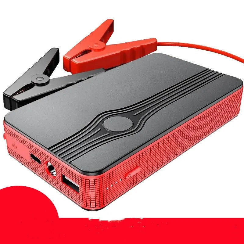 Red K4-E automobile emergency starting power supply unit with a data cable on a surface.