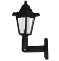 Black hexagonal solar-powered wall lamp for outdoor garden use, shown mounted on a fence