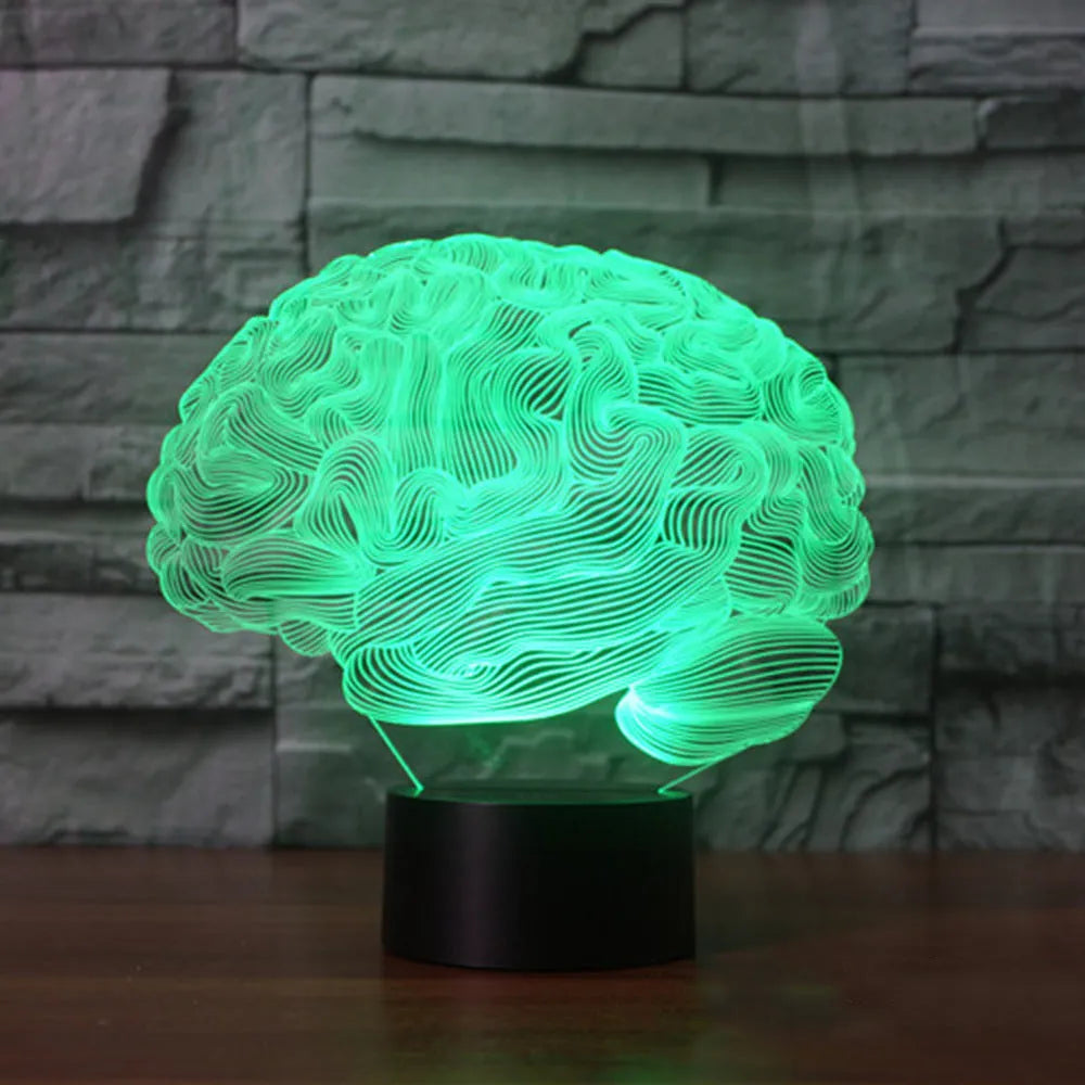 3D acrylic brain sculpture LED desk lamp with colourful illumination on a dark surface.