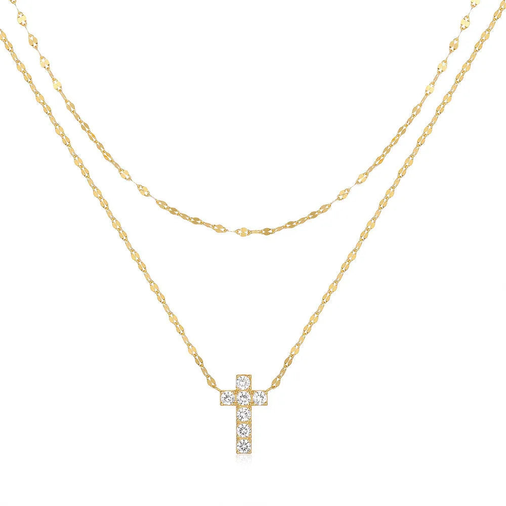 Close-up of a sterling silver double-layer geometric cross pendant on a clavicle chain.