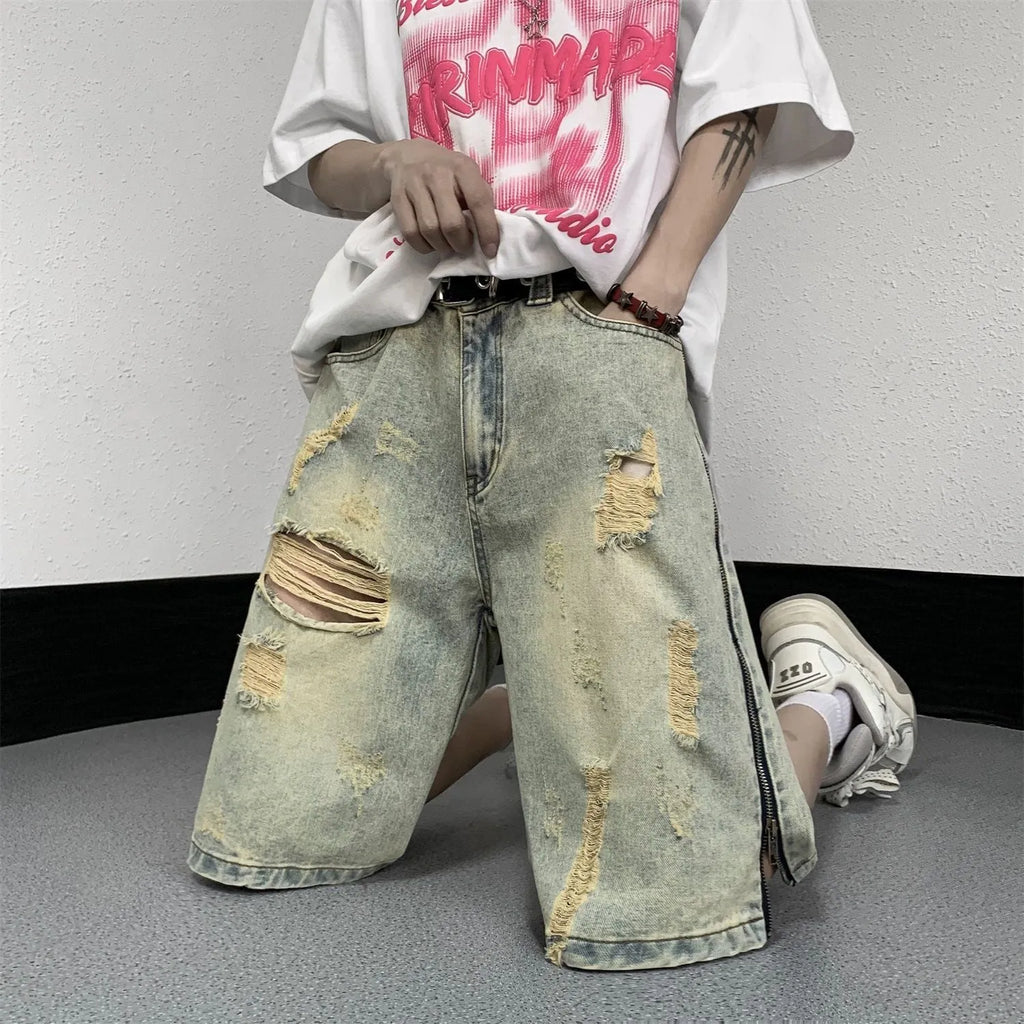 Man wearing blue retro ripped denim shorts with a loose fit and straight leg opening.