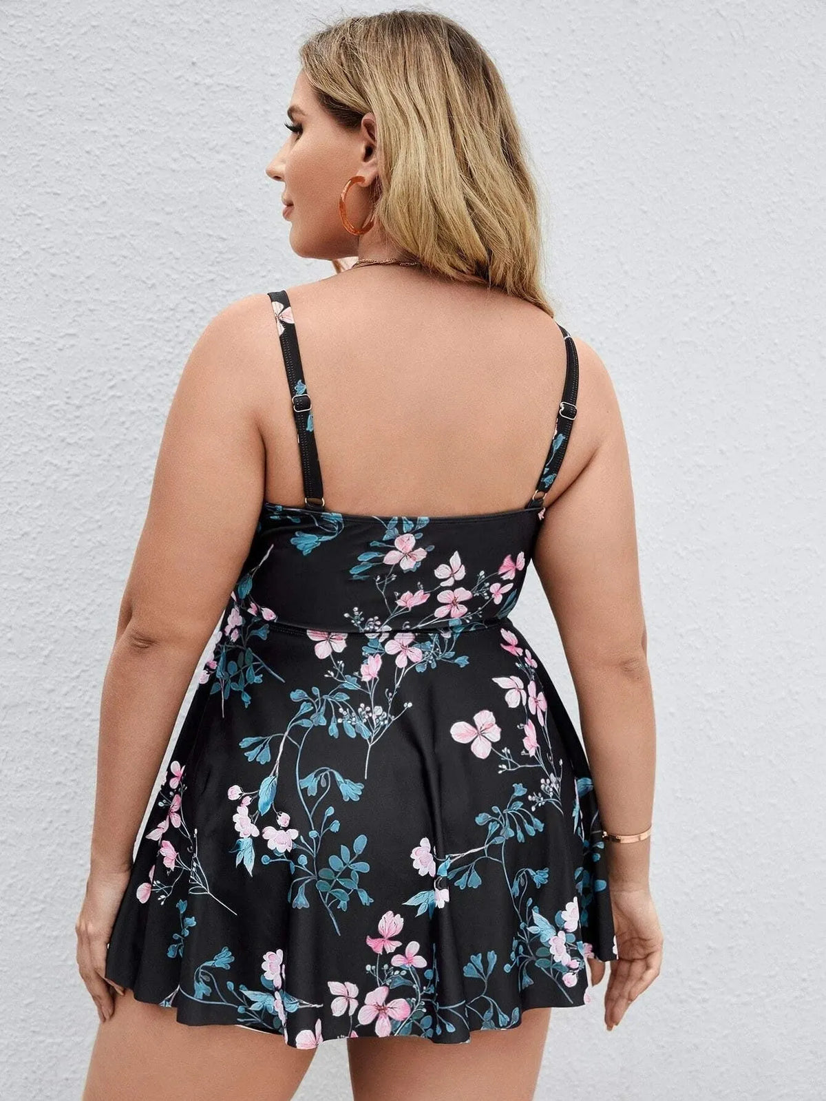Women's floral print one-piece swimsuit on a hanger, showing split colour design and plus size fit.