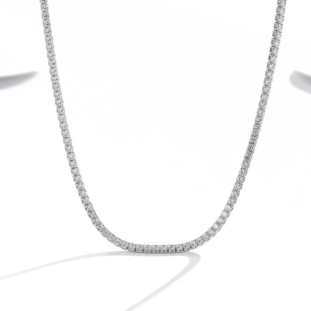 Close-up of a women's sterling silver necklace with round diamond-cut elements on a polished chain.