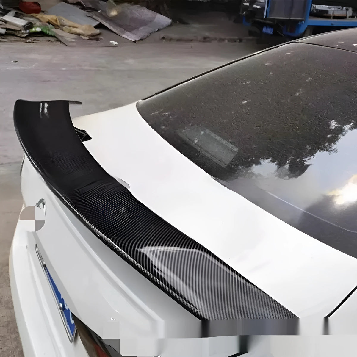 Universal fit car tail wing spoiler with punch-free mounting in carbon pattern finish.