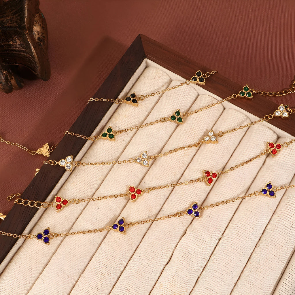 Women's stainless steel geometric bracelet with three diamonds and a coloured zircon stone in a triangular setting.