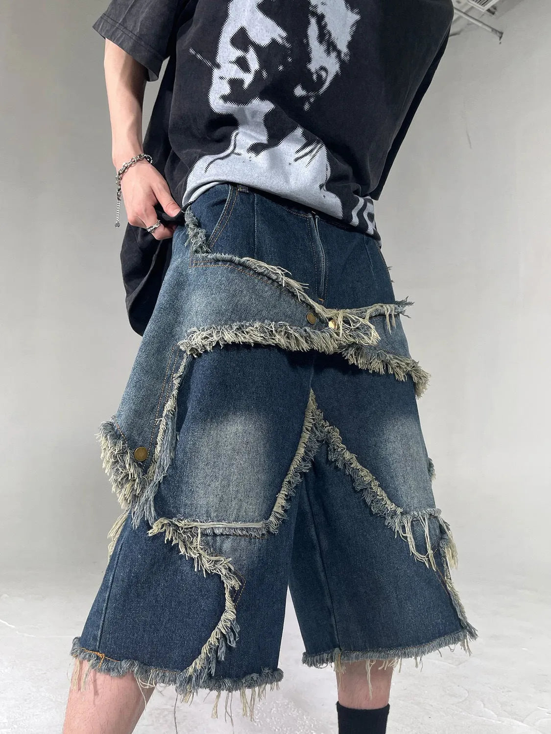Blue denim shorts with frayed five-pointed star design, loose fit, shown from front view