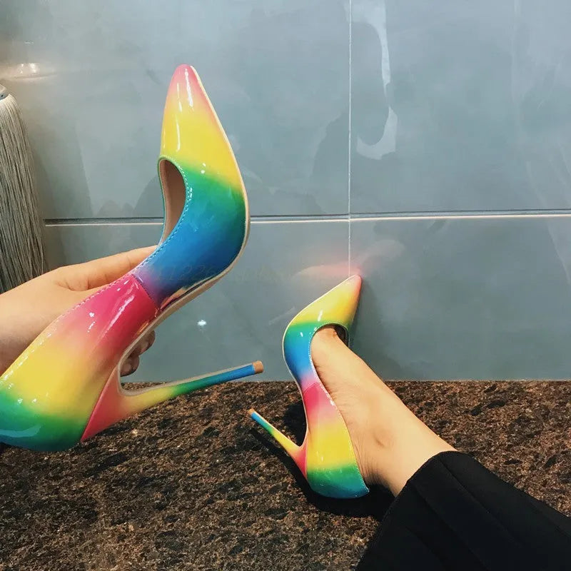 Rainbow patent leather pointed toe stiletto heels with thin ultra-high heel on white background