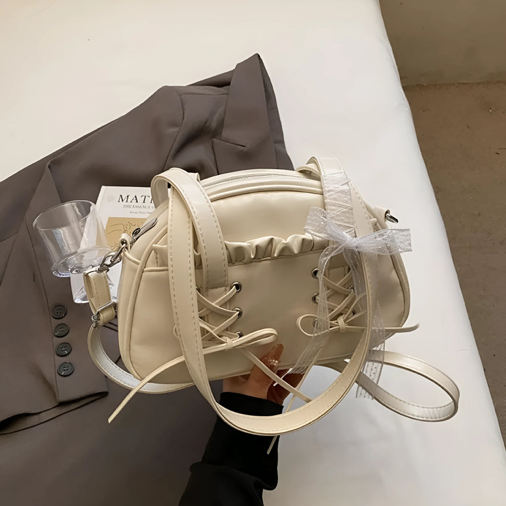 Women's milky white PU shoulder bag with bandage bow and stitching detail, showing internal phone pocket.