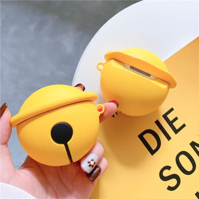 Yellow silicone AirPods case with attached bell charm showing charging port and LED cutouts
