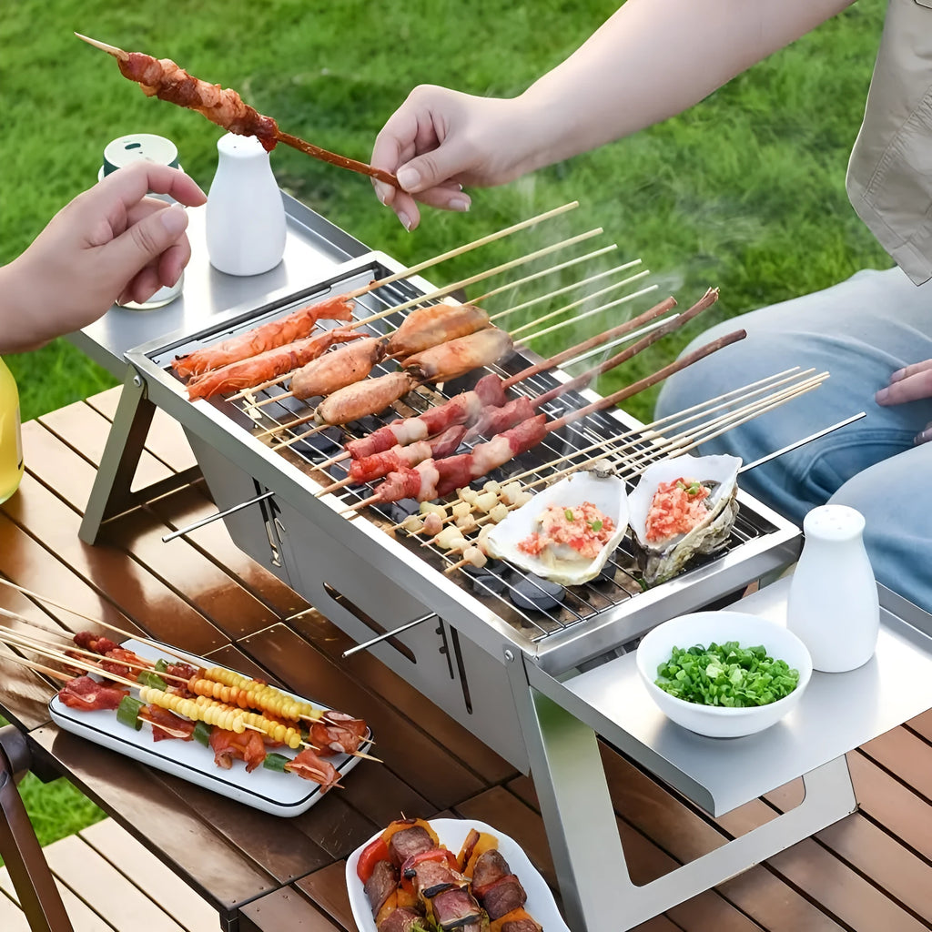Small folding portable charcoal grill shown set up for an outdoor barbecue.