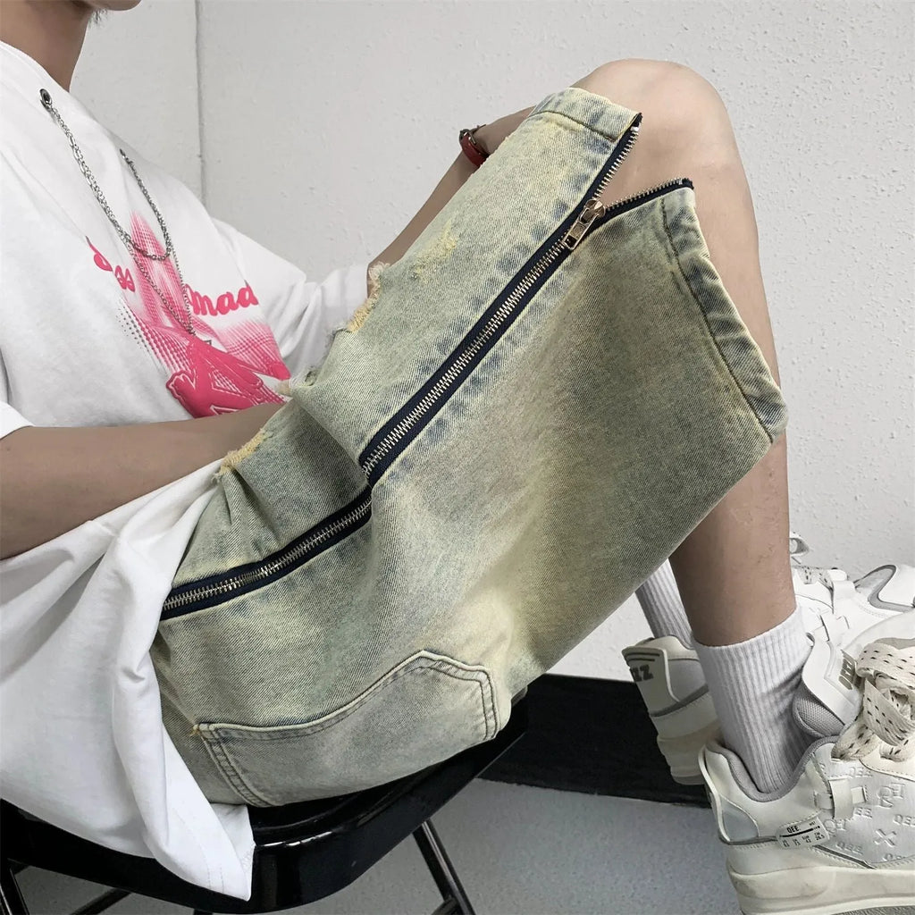 Man wearing blue retro ripped denim shorts with a loose fit and straight leg opening.