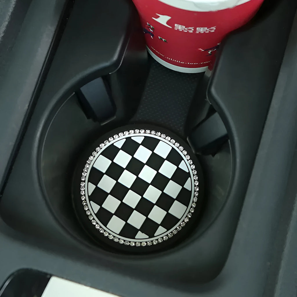 Black and white checkerboard pattern PVC plastic car cup holder mat placed in a vehicle centre console.