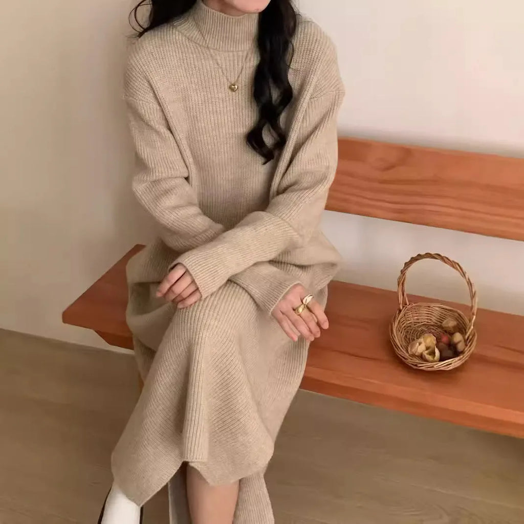 Solid colour knitted dress with half turtleneck collar and long sleeves, shown in a neutral colour.