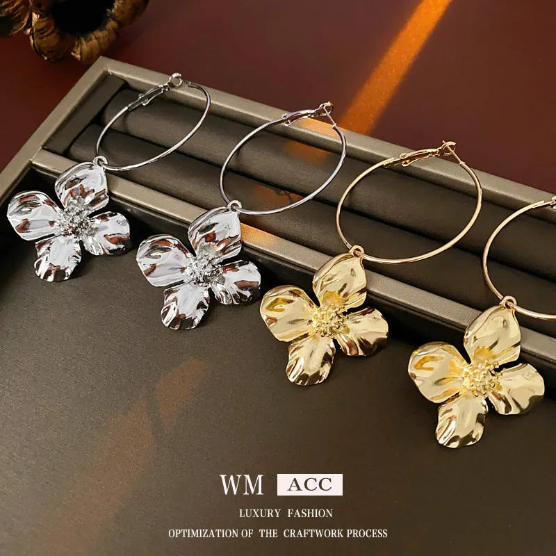 A pair of silver needle metal flower earrings with a geometric design in a gold or silver colour.