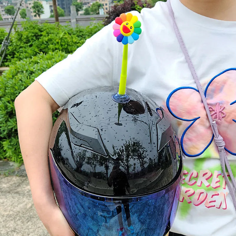 Yellow silicone sunflower helmet decoration with suction cup attachment swinging from motorcycle helmet